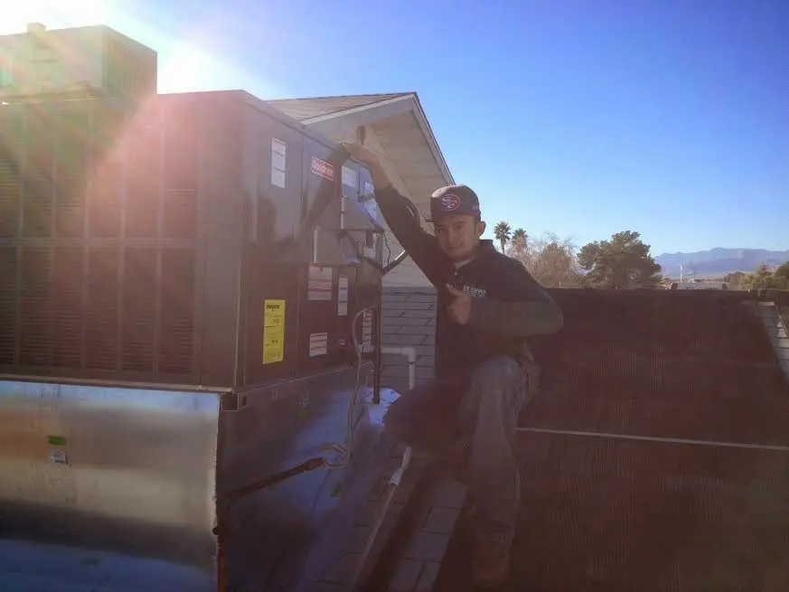 HVAC technician performing Boiler Repair on a rooftop unit in Waterloo